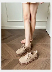 Detail of beige platform loafers featuring mixed leather and suede stitching with round laces
