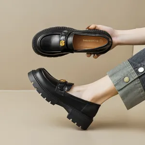 Women's black platform loafers with gold flower detail and chunky rubber soles