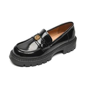 Classic black platform loafers with glossy finish and decorative golden floral buckle