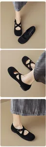 Close-up of black Mary Jane ballet flats with crossover straps and heart buckle detail