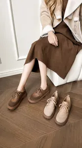 Close-up of retro round-toe platform loafers featuring stitched leather and suede details