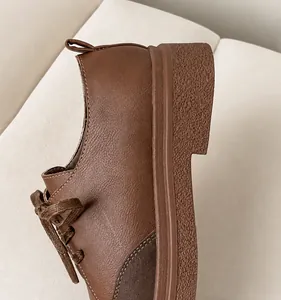 Detail view of brown leather platform shoe featuring a chunky heel and sturdy pull tab
