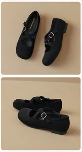 Detail view of black Mary Jane flat shoes with cross straps and silver metal buckles