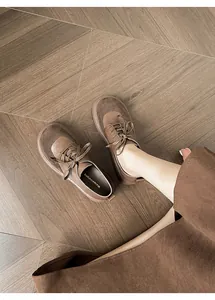 On-foot view of retro round-toe platform oxfords with brown leather and suede stitching