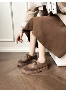 Close-up of retro brown patchwork loafers featuring thick rubber soles and matte leather finish