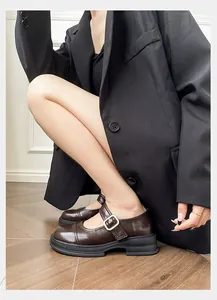 Close-up of brown Mary Jane shoes with vintage metal buckle and thick black platform sole