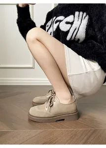 Detail of khaki platform Oxford shoes showing matte leather and suede stitching texture