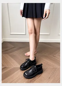 Close-up of black platform derby shoes with round toe and lace-up design in a casual setting