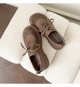 Detail view of brown vintage lace-up loafers with thick soles on a white textured bench