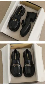 Detail of black matte platform loafers with distinctive gold heart pin metal buckle