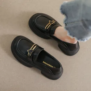 Women's black platform loafers with matte leather and a gold heart buckle detail