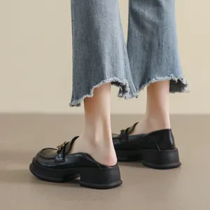 Retro black platform mule loafers with gold chain and thick sole worn with jeans
