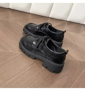 Detail view of black platform loafers showing leather texture and rugged lug sole
