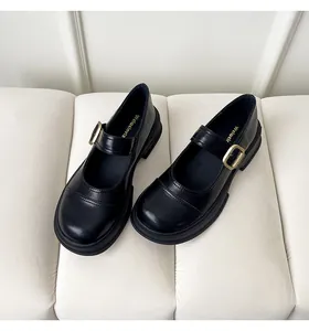 Detail of black platform Mary Jane shoes with gold buckle and smooth glossy finish