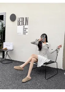 Buitenfoto van kaki suède instappers met dikke zolen op een achtergrond van grind