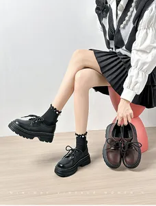 Detalle de mocasines con plataforma en negro y marrón con diseño vintage de cordones