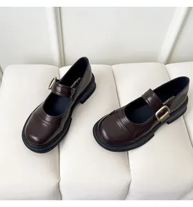 Close-up of dark brown Mary Jane platform shoes with glossy leather and metallic buckle