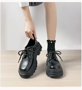 Detalle de mocasines negros con plataforma, acabado mate y costuras blancas en contraste