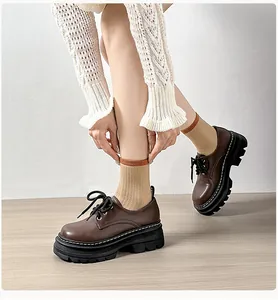 Detalle de mocasines con plataforma marrón oscuro con cordones y correas de moda