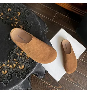 Bovenaanzicht van bruine suède muiltjes op zwart kant met comfortabele dikke zolen