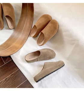 Detail van luxe suède muiltjes met dikke antislipzolen in bruine en kaki tinten