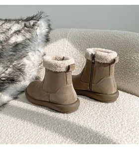 Dettaglio di stivali da neve con plateau marrone, fodera in peluche e zip laterale