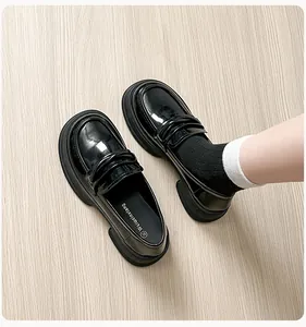 Macro view of shiny black patent leather loafers with thick soles and round toe detail