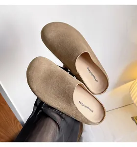 Detailopname van kaki suède muiltjes met zachte textuur en comfortabele plateauzool
