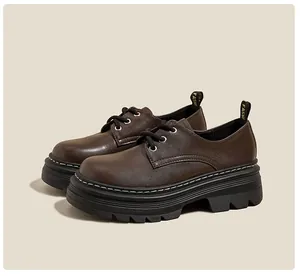 Detalle de zapato de plataforma marrón oscuro con suela track y costuras blancas