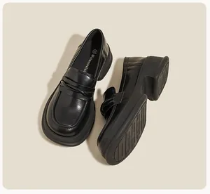Close-up of black leather platform loafers showing the thick non-slip rubber sole detail
