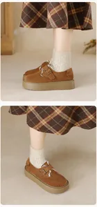 Close-up of brown suede platform boots featuring cozy faux shearling lining and metal buckle