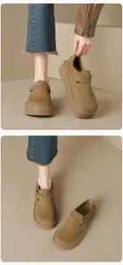 Detail view of khaki suede platform clogs featuring decorative metal buckle strap