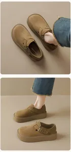 Close-up of brown suede platform Birkenstock-style shoes with metal buckle detail