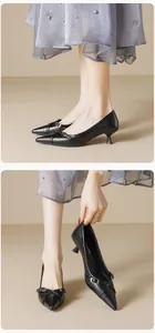 Makroansicht schwarzer spitzer Kitten-Heels aus mattem Leder mit Metallschnalle