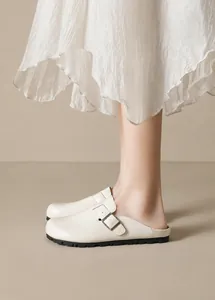 Minimalistische beige Leder-Pantolette mit Metallschnalle und schwarzer Gummisohle