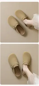 Dettaglio macro dei sabot in pelle scamosciata kaki stile Birkenstock con fibbie in metallo