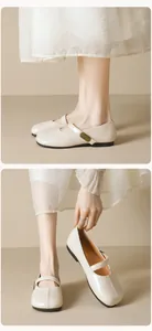 Detail of cream Mary Jane flat with round toe and fashion metal tag on strap