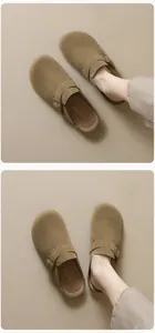 Dettaglio dei sabot in camoscio kaki con cinturini regolabili e fibbie in bronzo scuro