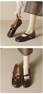 Detailed view of dark brown round-toe Mary Jane flats with metal buckle and soft leather