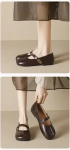 Close-up of dark brown patent leather Mary Jane shoe with metal buckle and round toe design