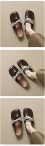 Macro shot of dark brown flat mule shoes featuring a floral fabric bow detail and soft leather
