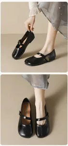 Detailed close-up of matte black Mary Jane flats with round toe and antique buckle strap