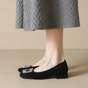 Elegant black suede square toe flats with sparkling rhinestone buckle on a model
