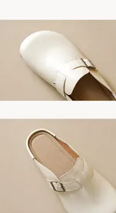 Detaillierte Makroansicht der Vintage Kupferschnalle und beiges Leder des Mules