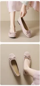 Detailed close-up of pink suede ballet flats with delicate bow and soft matte texture