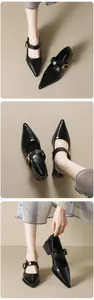 Close-up of black pointed Mary Jane shoe with gold buckle and stable chunky heel