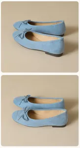 Detail view of light blue suede ballet flats with bow tie and contrast stitching