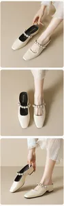 Detail von eleganten cremeweißen Mules mit eckiger Spitze und Perlen-Strass-Verzierung