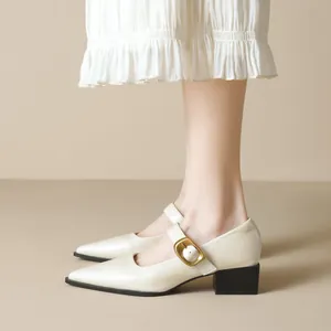 Classic ivory pointed-toe Mary Jane shoes with thick heels and gold buckle detail