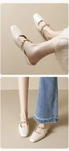 Detail of cream mule shoes with square toe and gold pyramid studs on the front strap